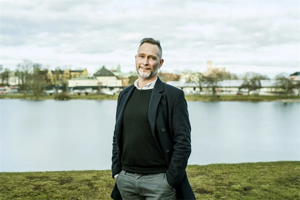 Man står vid ett vattendrag och tittar in i kameran.