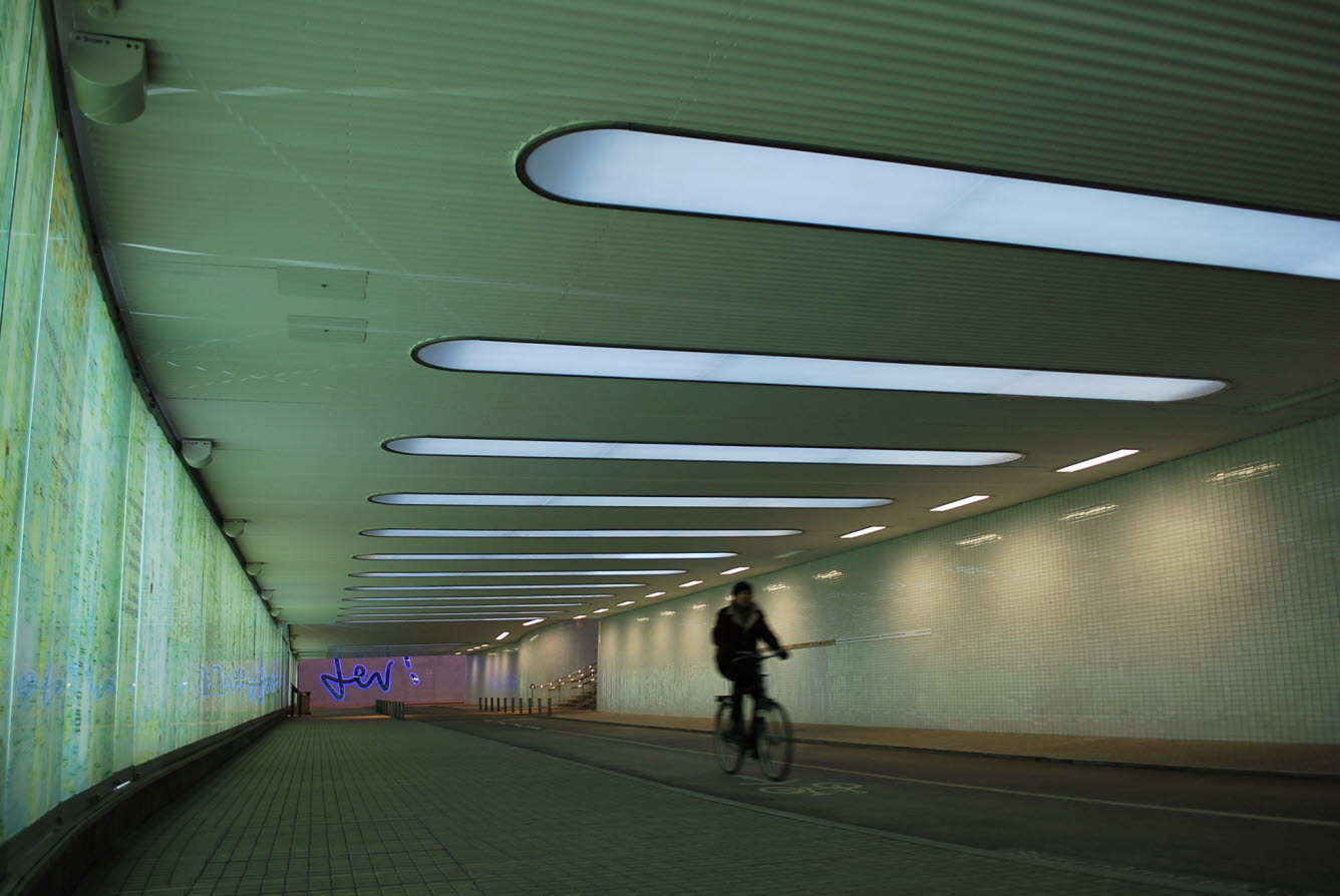 Bilden visar en man som cyklar i en ljus, trygg och vacker passage under Umeå C.