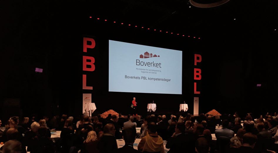 Publik framför scen med personer på och bokstäverna PBL
