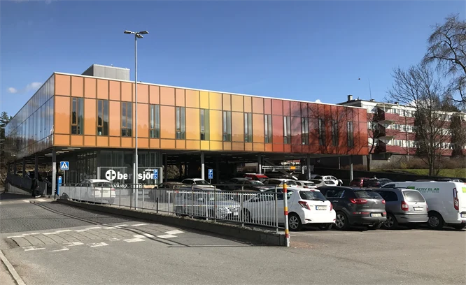 Byggnad med parkerade bilar framför.