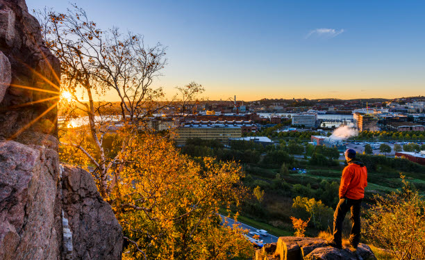 Foto på en person som blickar ut över en stad i solnedgången. Foto: Mikael Svensson/Scandinav.