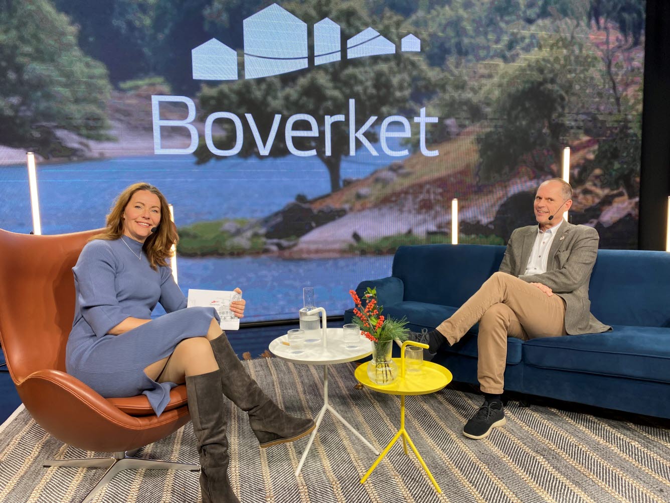 Generaldirektör Anders Sjelvgren och moderator Julia Bendelin sitter i studio med soffa, bord och fåtölj