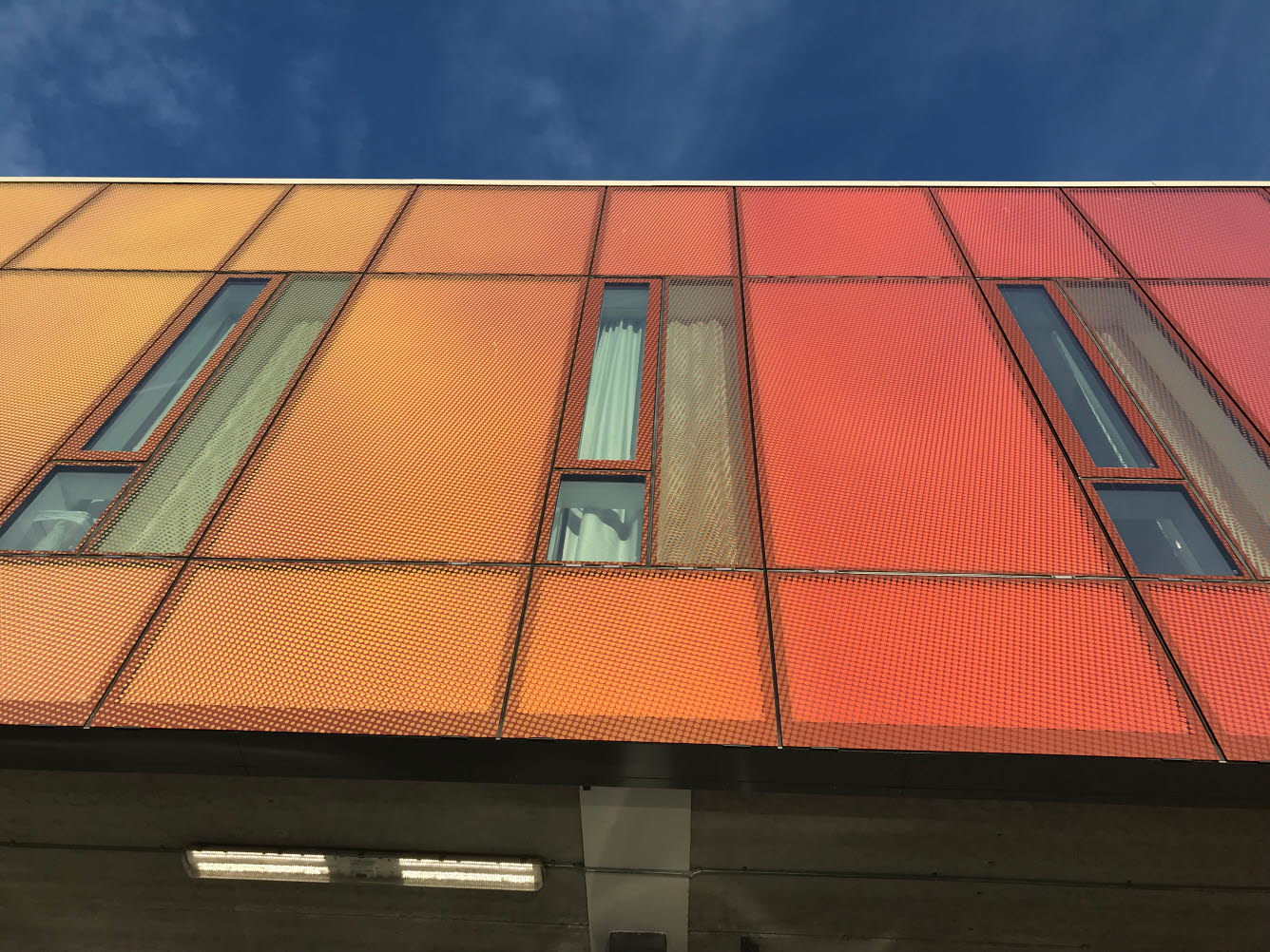 Fasad på byggnad som är tryckt med färgskalan orange till rött.