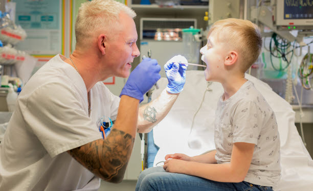 Tandläkare som undersöker munnen på ett barn.