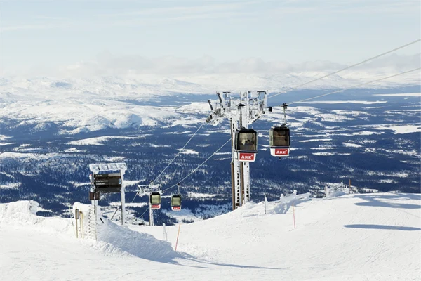 Foto på gondolbana över en snöig backe.