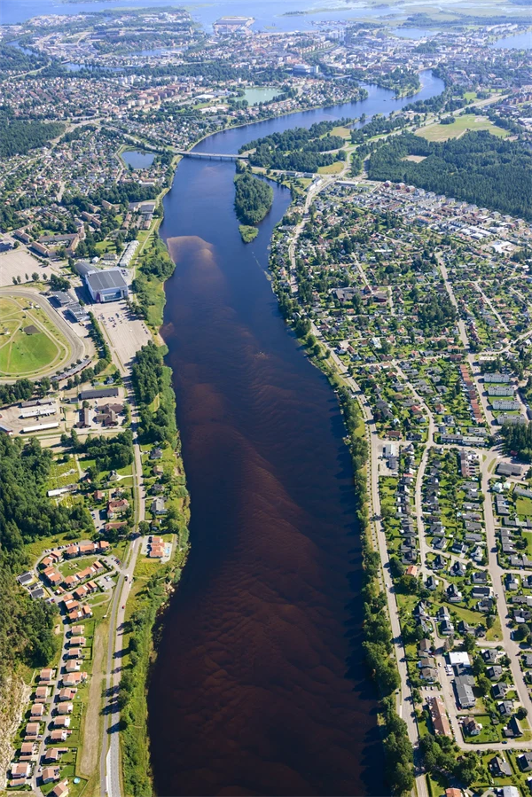 Flygbild över Klarälven med bbeyggelse vid sidorn av älven.