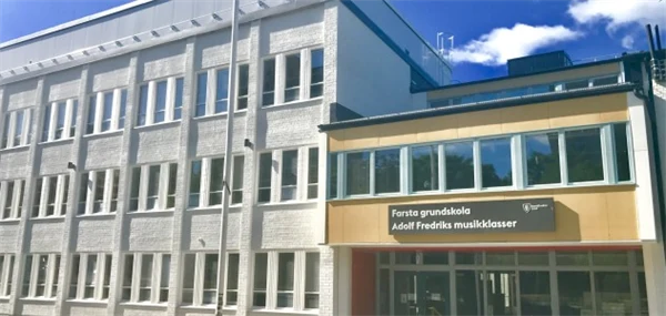 Foto på skolbyggnad med skylen Farsta grundskola Adolf Fredriks Musikklasser.