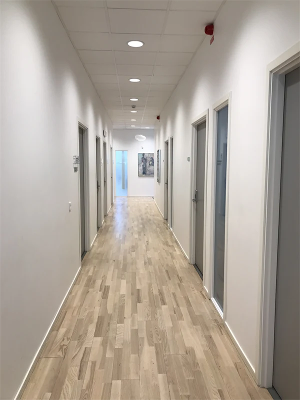 Foto på vårdcentralens vita korridor med tavlor.