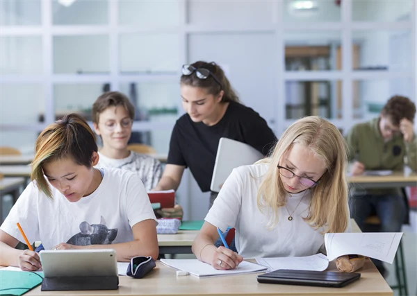 Foto på lärare och elever i klassrum.