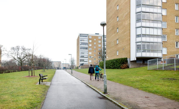 Människor promenerar på trottoar utanför flerbostadshus. Foto: Peter Kroon