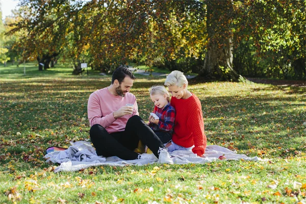 Familj som har picknick i en park.