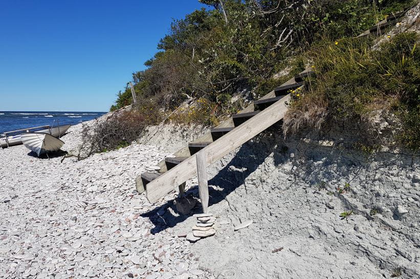 En trappa som leder ner till stranden saknar kontakt med marken till följd av erosion. Foto:n.
