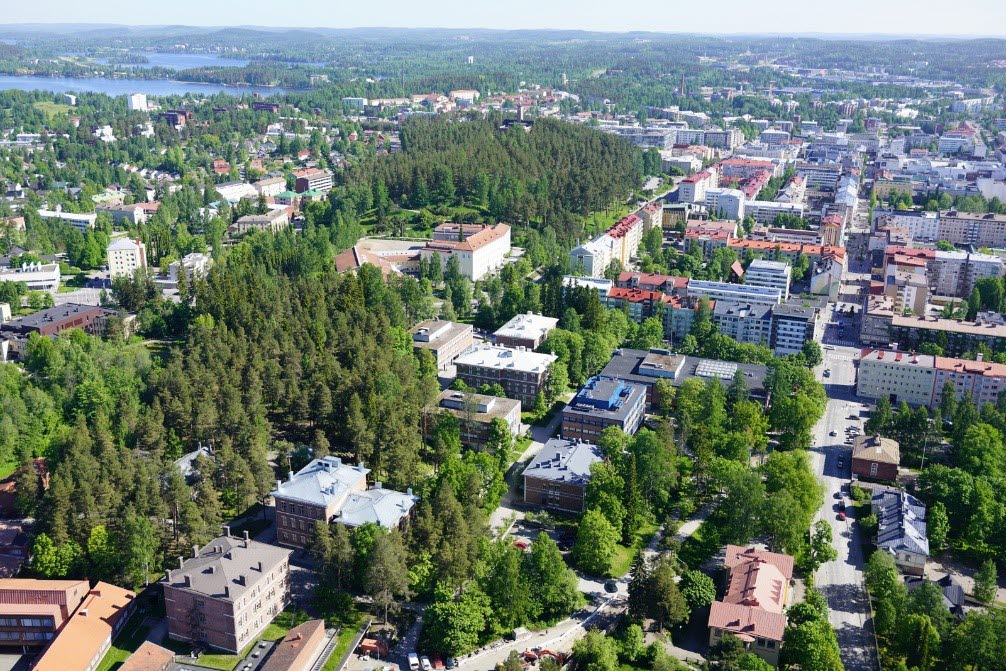 Flygfoto som visar skog, fastigheter och sjöar.