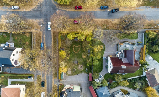 Flygfoto som visar en fyrvägskorsning, grönytor och hus.