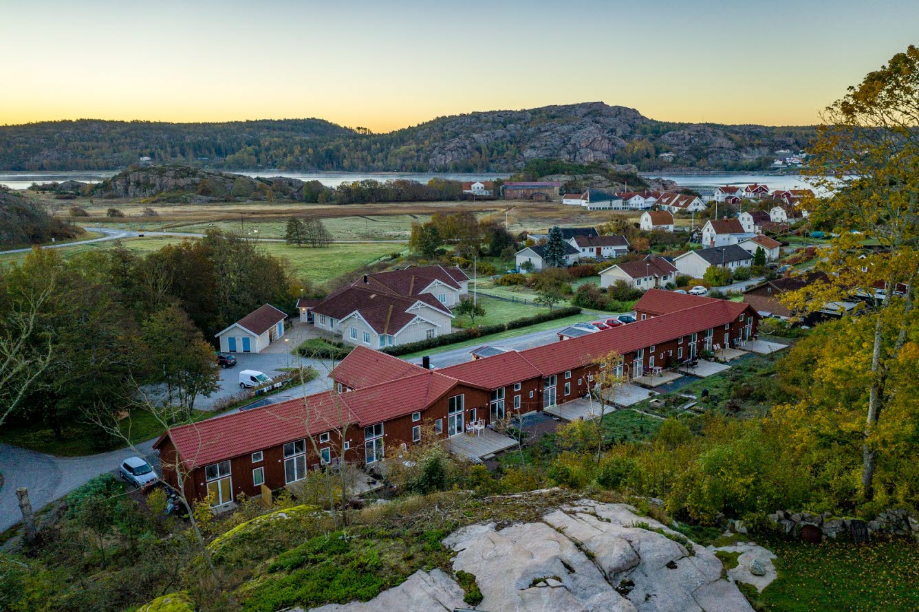 Flygfoto över bostäder vid foten av ett berg.