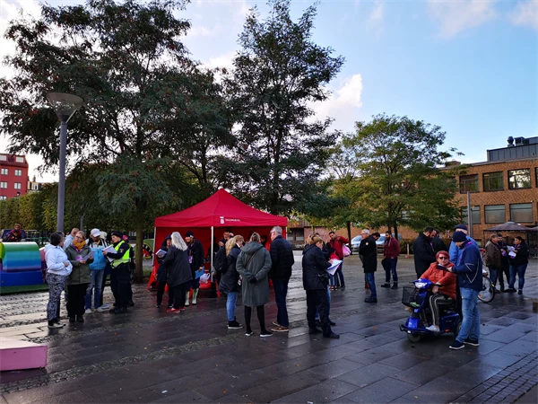 Människor som möts och pratar på ett torg.