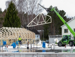 En kranbil lyfter takstolar på plats. Foto: Scandinav