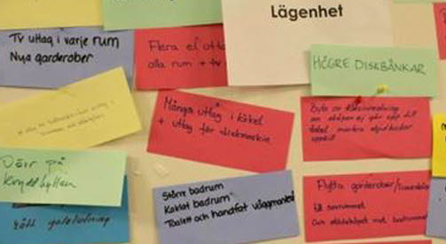 Post it-lappar i olika färger sitter på en vägg