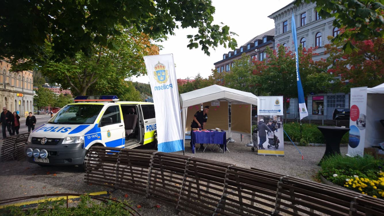 Bilden visar en stor polisbill samt två tält, där det står en polisman. Bilden vill visa förberedelser inför ett dialogtillfälle i centrala Sundsvall.