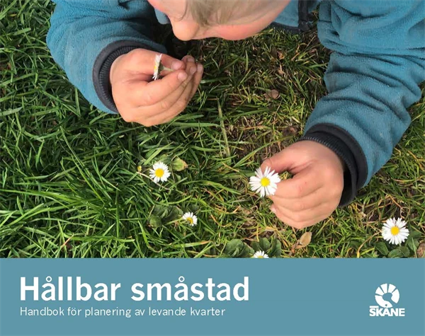 Framsidan på broschyren Hållbar småstad. Ett barn ligger i gräset och luktar på blommor.