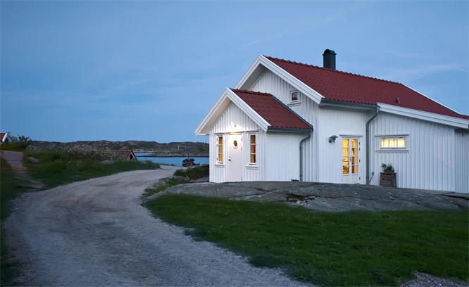 Ett vitt hus vid en landsväg i skymningen. Foto: Stefan Isaksson/Johnér Bildbyrå