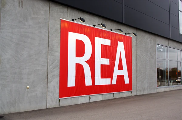Foto av en röd vepa med vit text Rea på en husfasad.