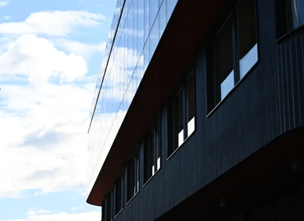 Boverkets kontor, svart träfasad med stora glasfönster som speglar himlenn.