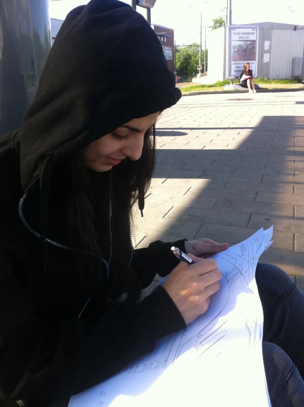 Bilden visar en yngre kvinna som utför en platsobservation inför gestaltningen av resecentrum i Angered.