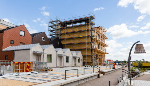 Byggarbetsplats med flerbostadshus och radhus.