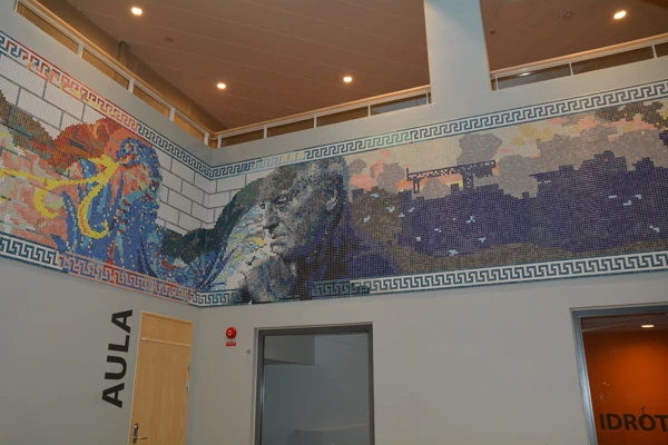 Mosaik på väggen som skapar figurer och mönster i olika färger.