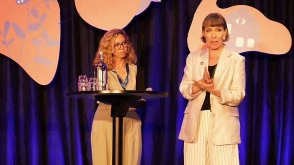 Foto av två kvinnor i ett samtal på konferensens scen.