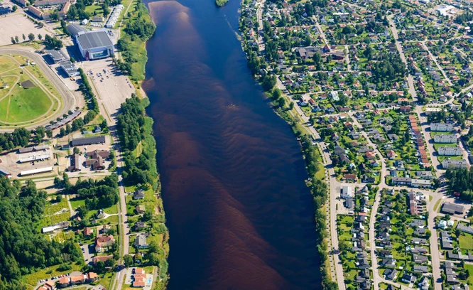 Flygfoto över stad vid vattendrag.