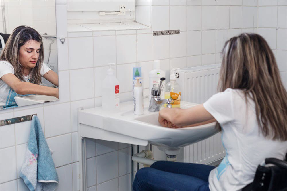 Kvinna i rullstol vid handfat i badrum. Foto: Marie Linnér/Scandinav.